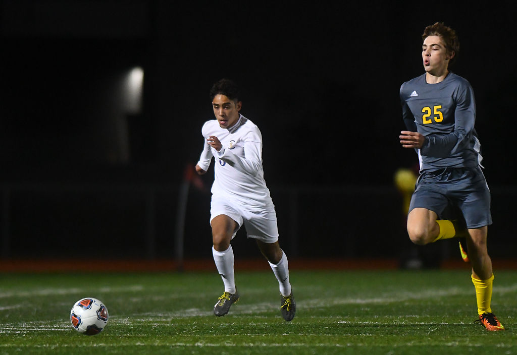 Nick Lugo tries to run the ball along the sidelines as Rock Bridge defender Jack Jenne tracks back